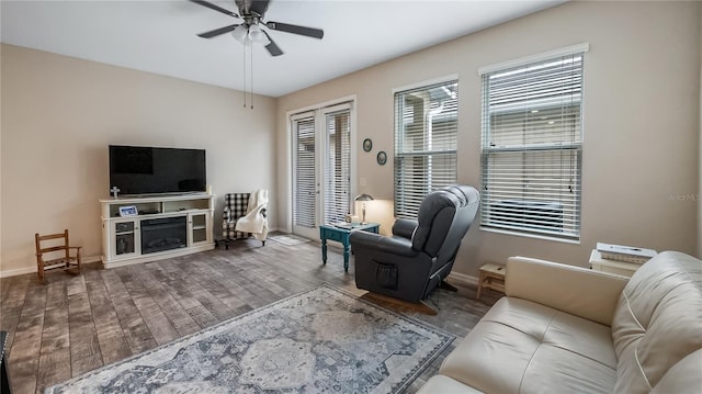 living room with wood finished floors, baseboards, and a ceiling fan