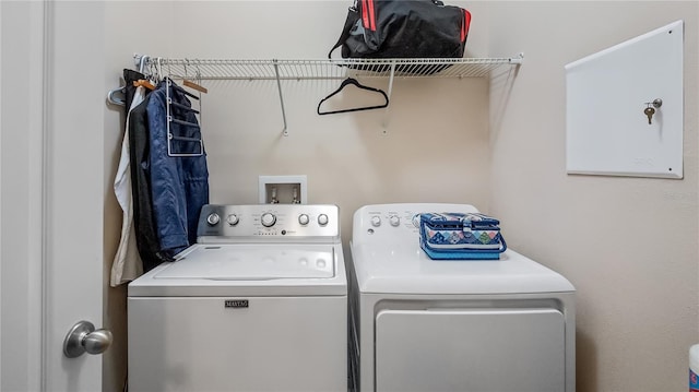clothes washing area with washer and clothes dryer and laundry area