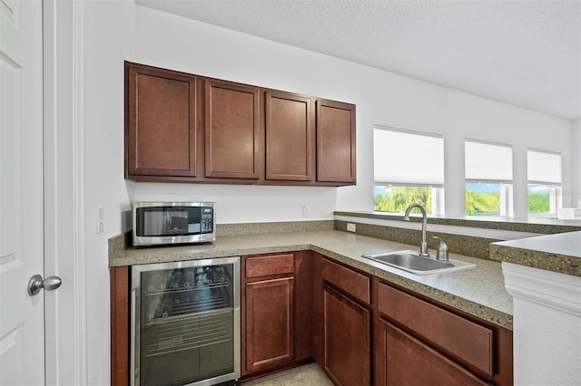 1802 Candlenut Cir, Apopka, FL 32712 - kitchen with wine cooler, stainless steel microwave, a textured ceiling, and a sink