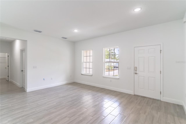 interior space featuring light wood-style flooring, visible vents, and baseboards