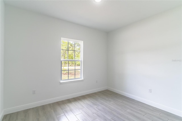 unfurnished room with light wood-style flooring and baseboards