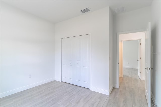 unfurnished bedroom featuring visible vents, baseboards, and light wood-style flooring
