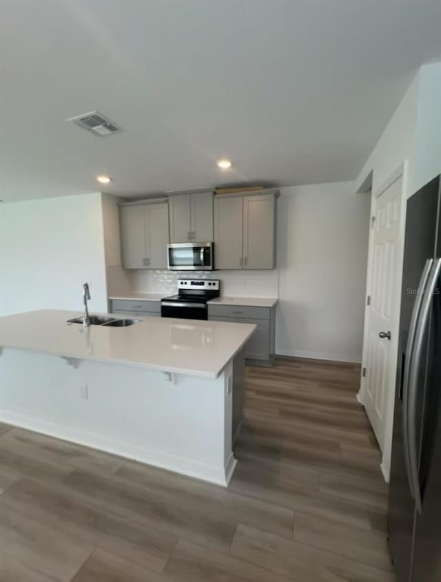 6028 Bimini Ave, Haines City, FL 33844 - kitchen with stainless steel appliances, gray cabinetry, a sink, dark wood-style flooring, and recessed lighting