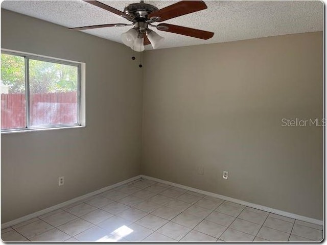 empty room with baseboards, a ceiling fan, and a textured ceiling