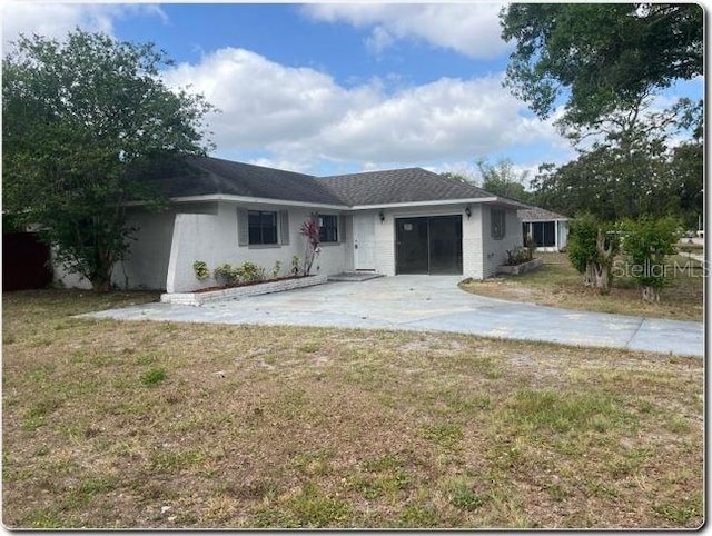 single story home featuring an attached garage, driveway, and a front lawn