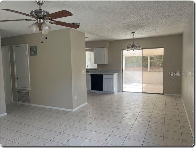 4736 Southold St, Orlando, FL 32808 - unfurnished living room featuring light tile patterned floors, ceiling fan with notable chandelier, a healthy amount of sunlight, and a textured ceiling