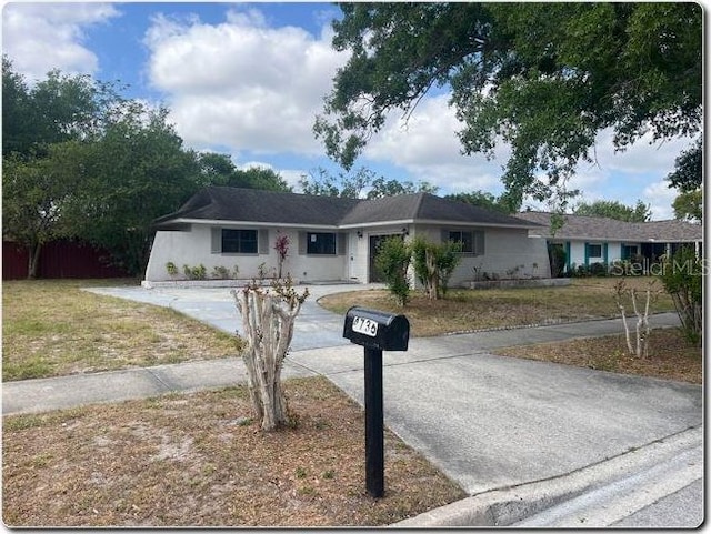 4736 Southold St, Orlando, FL 32808 - single story home with concrete driveway, an attached garage, and a front lawn
