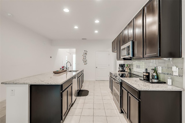 kitchen featuring light tile patterned flooring, recessed lighting, a sink, and appliances with stainless steel finishes