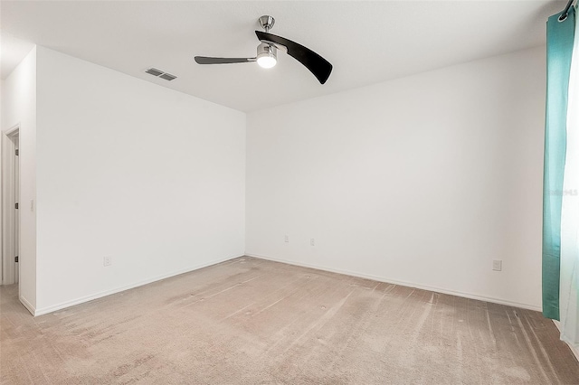 spare room featuring baseboards, visible vents, light colored carpet, and a ceiling fan