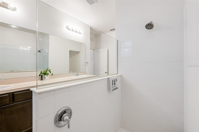 bathroom featuring vanity, visible vents, and walk in shower