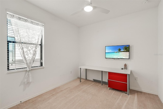 office featuring light colored carpet, baseboards, and ceiling fan