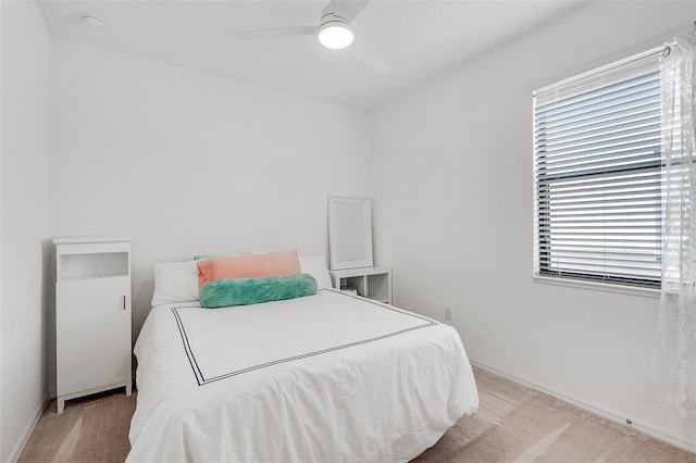 bedroom featuring light carpet, baseboards, and a ceiling fan