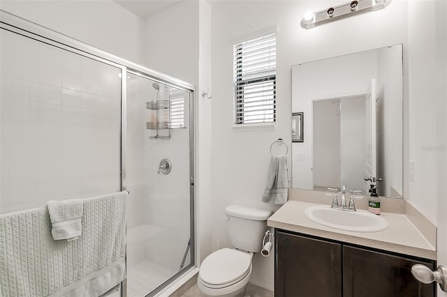 full bathroom featuring toilet, a stall shower, and vanity