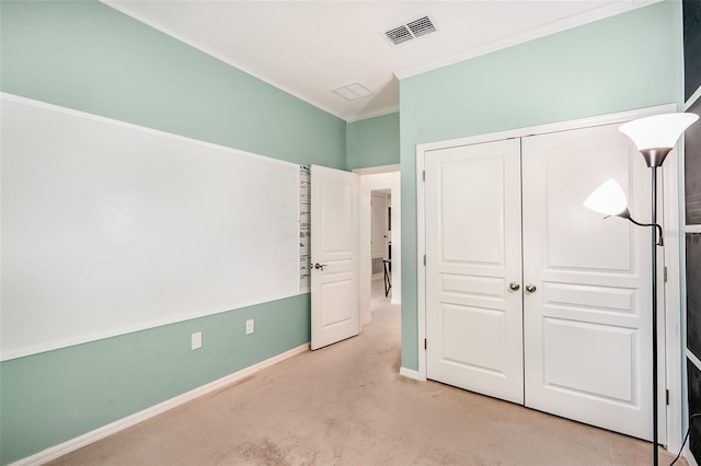 unfurnished bedroom with baseboards, a closet, ornamental molding, light carpet, and visible vents