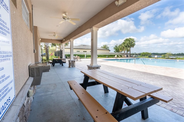 view of patio / terrace featuring a community pool, fence, and a ceiling fan