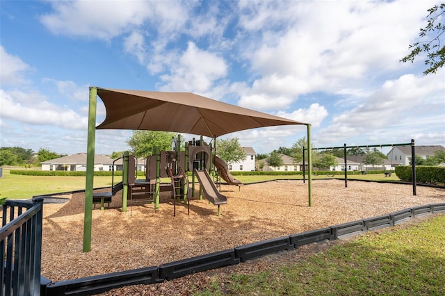 communal playground featuring a yard and a residential view