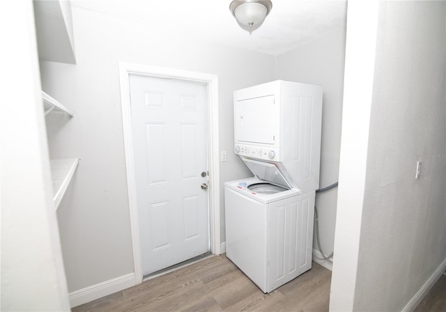 1831 Aaron Ave, Orlando, FL 32811 - laundry room featuring light wood finished floors, baseboards, stacked washing maching and dryer, and laundry area