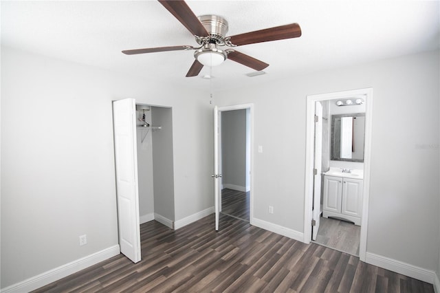 1831 Aaron Ave, Orlando, FL 32811 - unfurnished bedroom featuring dark wood-type flooring, baseboards, a sink, connected bathroom, and a closet