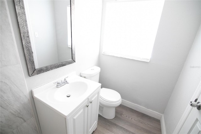 1831 Aaron Ave, Orlando, FL 32811 - bathroom featuring toilet, vanity, wood finished floors, and a wealth of natural light