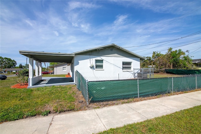 1831 Aaron Ave, Orlando, FL 32811 - view of property exterior with a carport, fence, stucco siding, and a yard
