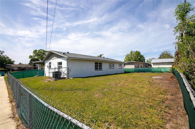 1831 Aaron Ave, Orlando, FL 32811 - back of property featuring a fenced backyard, cooling unit, stucco siding, and a yard