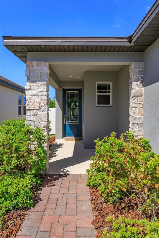 doorway to property featuring stucco siding