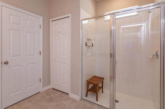full bath with a shower stall and tile patterned flooring