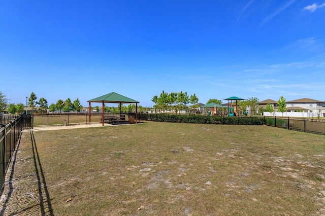 view of yard with a gazebo, playground community, and fence