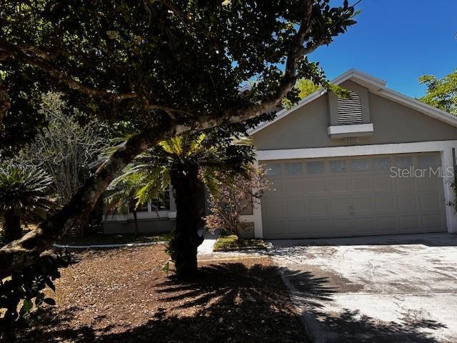 view of front of property featuring concrete driveway, stucco siding, and a garage