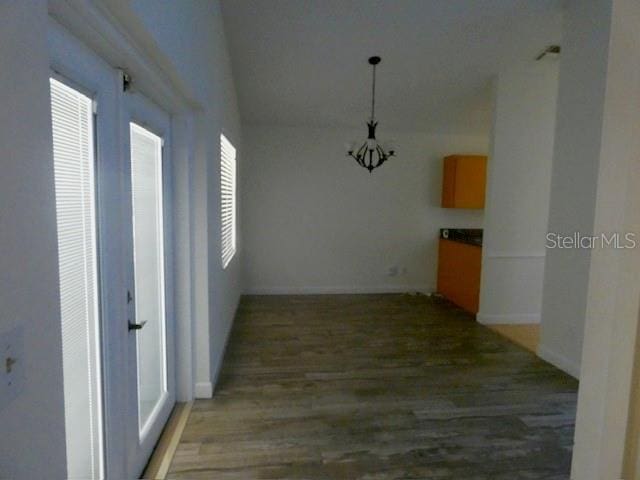 hallway featuring wood finished floors and baseboards