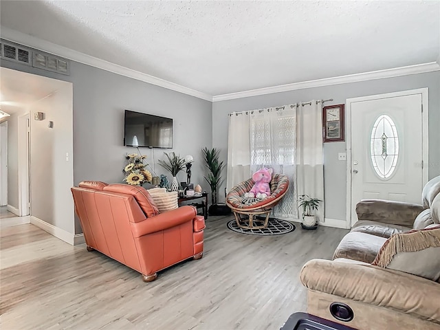 living room featuring a textured ceiling, visible vents, crown molding, wood finished floors, and a wealth of natural light