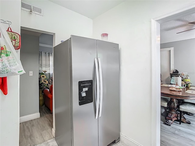 kitchen with baseboards, visible vents, stainless steel fridge, and light wood-type flooring