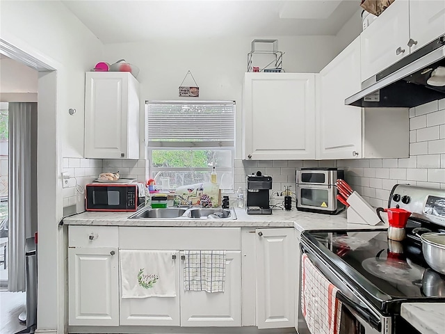 kitchen with stainless steel electric range oven, under cabinet range hood, white cabinetry, black microwave, and a sink