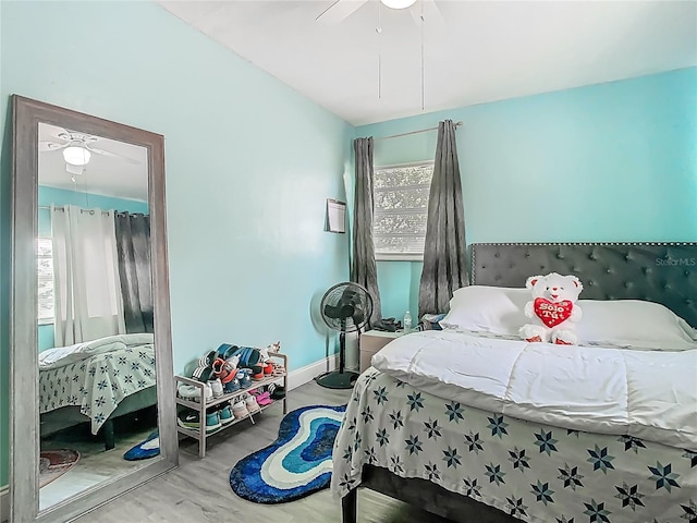 bedroom featuring baseboards, ceiling fan, and wood finished floors