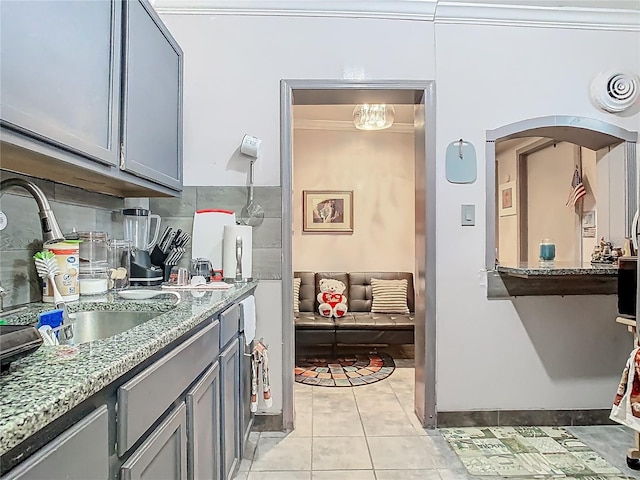 kitchen with light tile patterned flooring, visible vents, a sink, light stone counters, and gray cabinets