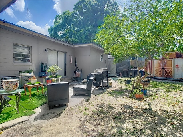 view of yard featuring an outdoor structure, a shed, and a patio
