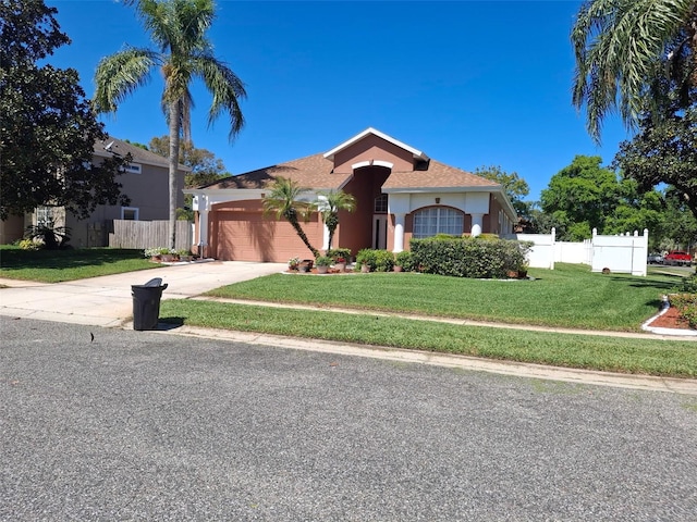 450 Morning Blossom Ln, Oviedo, FL 32765 - mediterranean / spanish-style home featuring fence, a front lawn, stucco siding, an attached garage, and concrete driveway