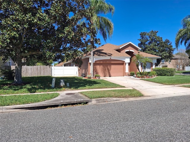 450 Morning Blossom Ln, Oviedo, FL 32765 - mediterranean / spanish-style house with fence, a front lawn, stucco siding, and a garage