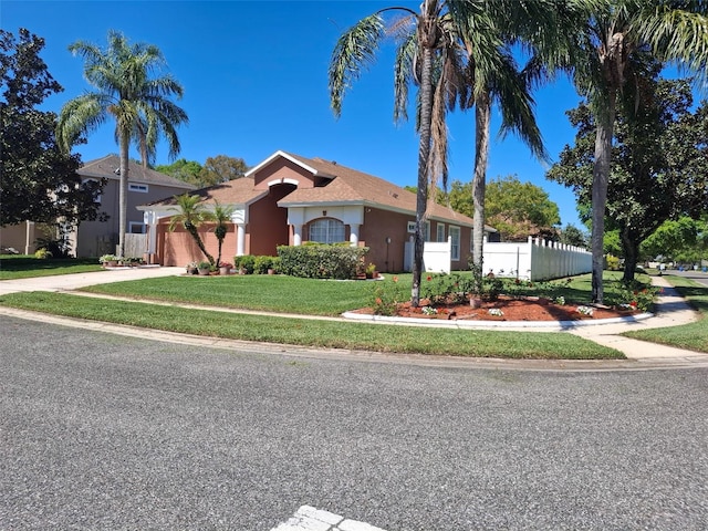 450 Morning Blossom Ln, Oviedo, FL 32765 - view of front of home with a garage, concrete driveway, fence, a front yard, and stucco siding
