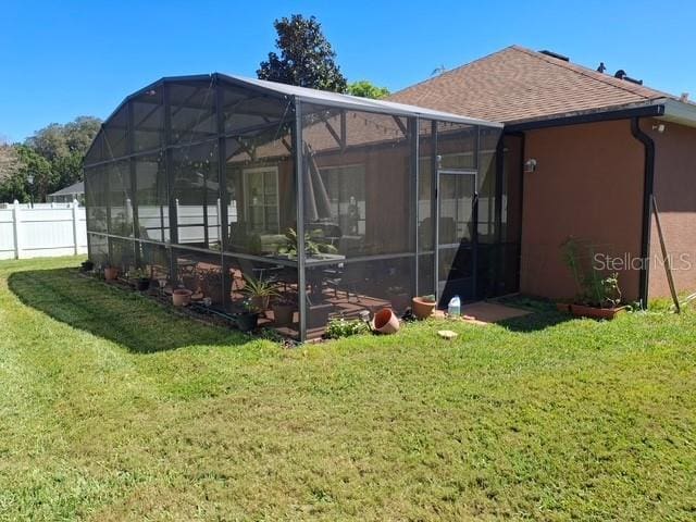 450 Morning Blossom Ln, Oviedo, FL 32765 - rear view of property with a yard, fence, roof with shingles, and stucco siding