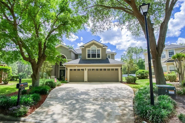 traditional home featuring an attached garage, stucco siding, a front yard, and concrete driveway