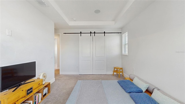 13241 Cormack Ln, Orlando, FL 32827 - carpeted bedroom with a barn door, a raised ceiling, baseboards, and visible vents