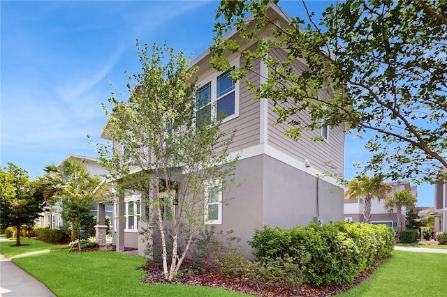 13241 Cormack Ln, Orlando, FL 32827 - view of home's exterior with a lawn and stucco siding
