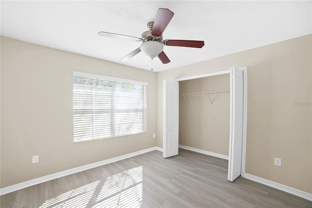 unfurnished bedroom with a closet, baseboards, ceiling fan, and wood finished floors