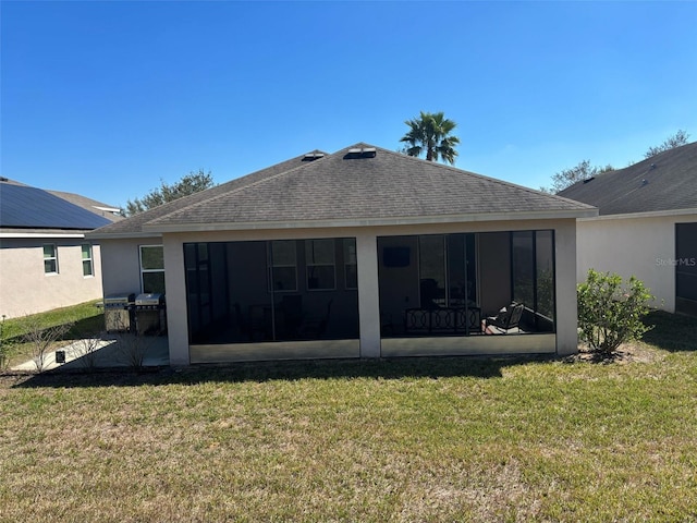 back of house with a yard, stucco siding, and a sunroom
