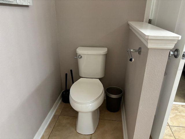bathroom featuring tile patterned floors, baseboards, and toilet