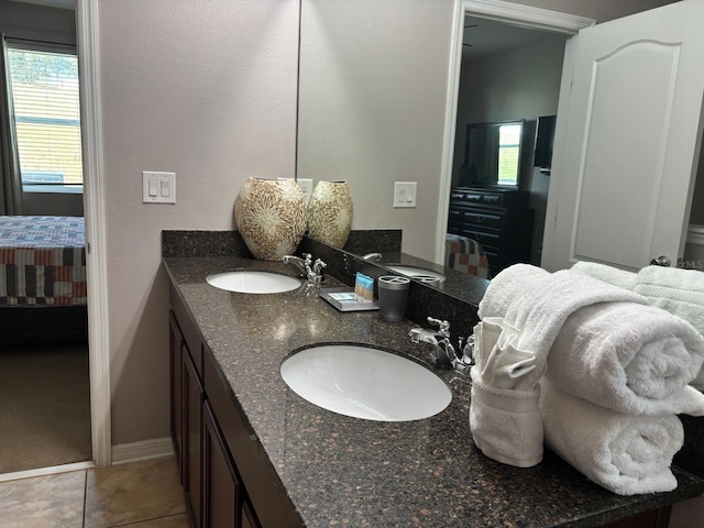 bathroom featuring plenty of natural light, ensuite bath, and a sink