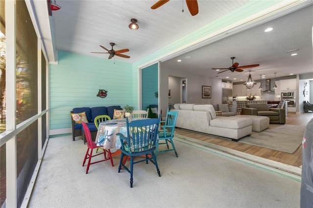 sunroom / solarium with a ceiling fan, outdoor lounge area, and outdoor dining space