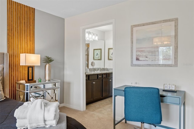 interior space with a sink, light carpet, ensuite bathroom, baseboards, and an inviting chandelier