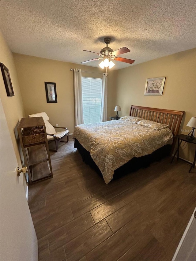 bedroom featuring dark wood-style flooring, a textured ceiling, and ceiling fan